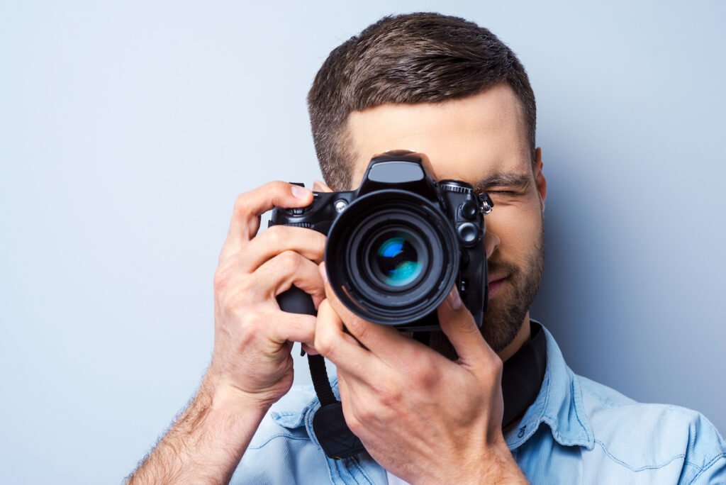 Ein Fotograf schaut durch seine Kamera, um ein Foto zu schießen.