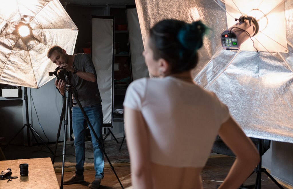 Weibliches Model wird bei einem Fotoshooting von einem Fotografen fotografiert.